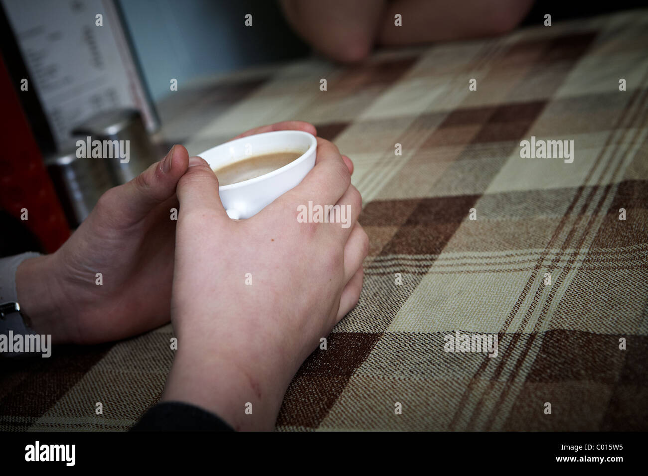 A person holds a cup of tea in a greasy spoon cafe Stock Photo