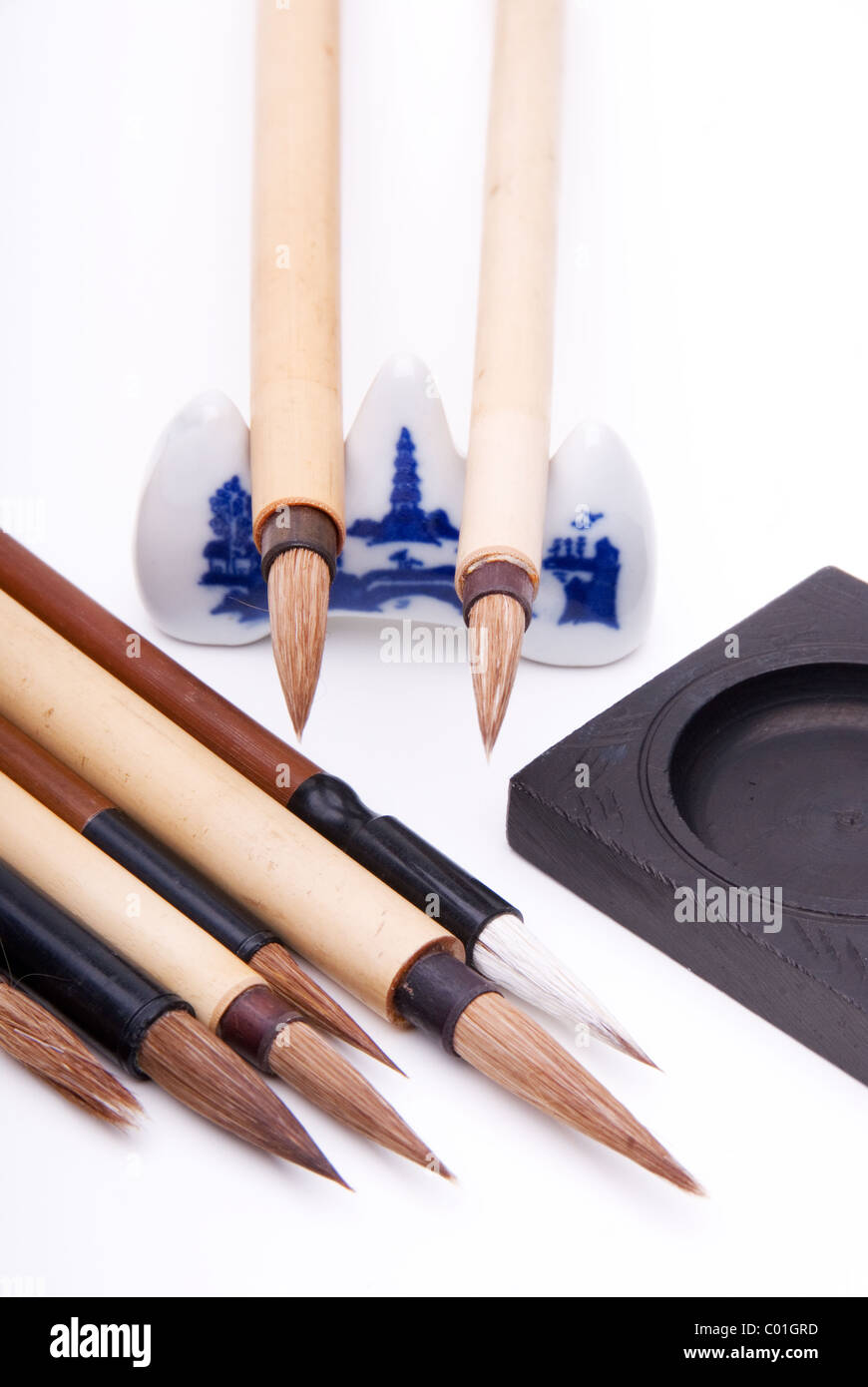 Chinese painting brushes with ink stone and porcelain rest. Stock Photo
