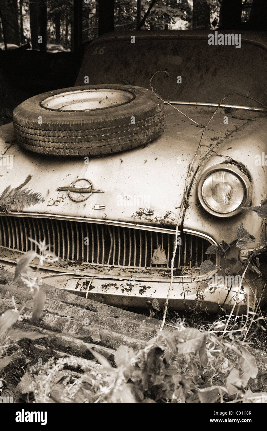 Wrecked car with tire on the hood at the oldtimer scrapyard sepia toned, Kaufdorf, Switzerland Stock Photo