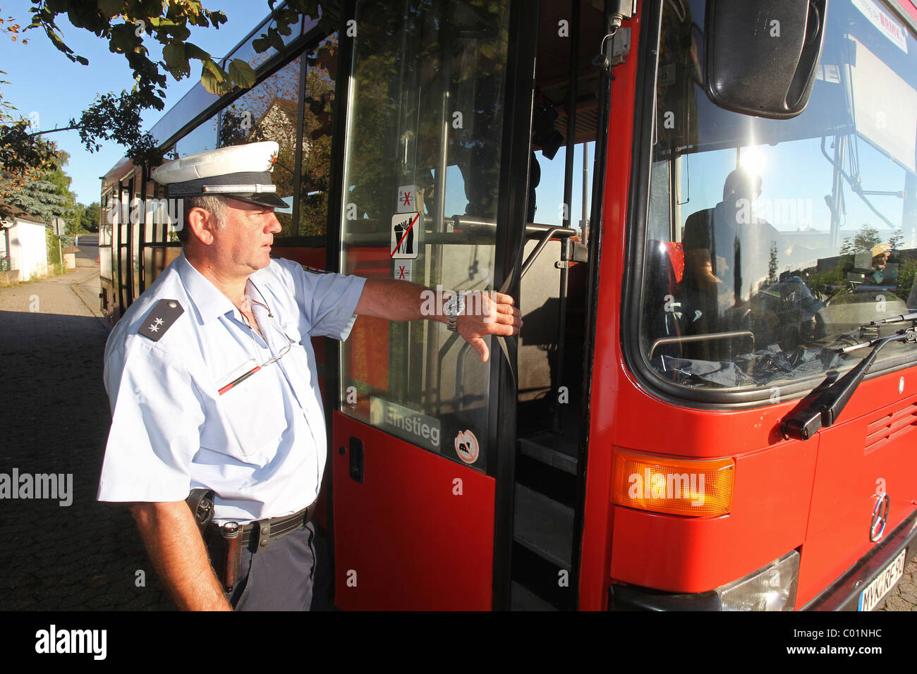 Police officer checking a school bus, Plaidt, Rhineland-Palatinate, Germany, Europe Stock Photo