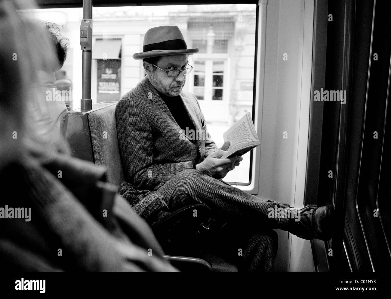 Ghent in East FlandersOostVlaanderen, Belgium. Man reading his book while travelling on a tram