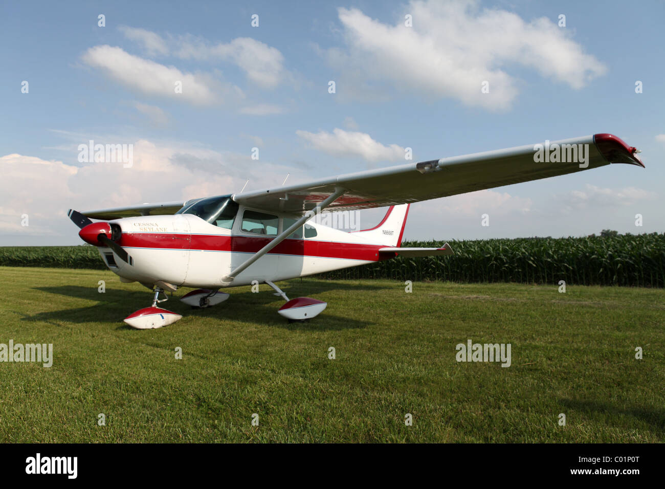 Cessna airplane on grass airstrip in Iowa near corn field. Stock Photo