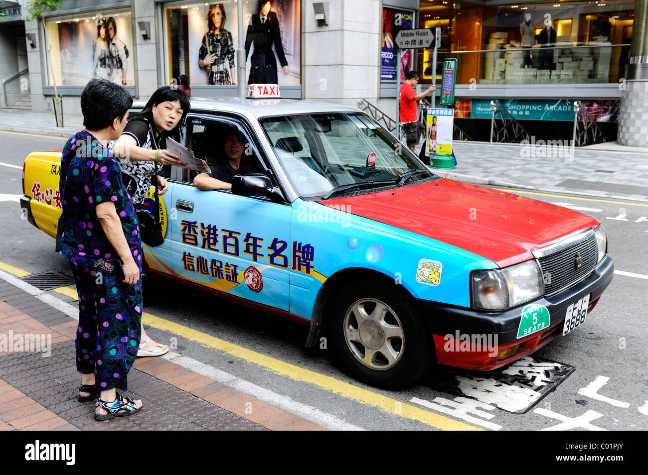 Two women asking a cab driver for directions, Hong Kong, China, Asia Stock Photo