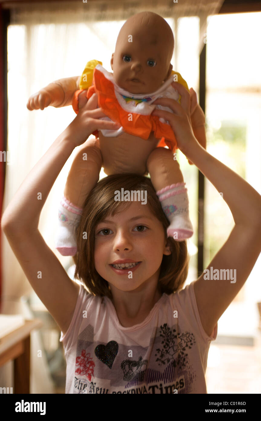 Young girl playing with toy doll Stock Photo - Alamy