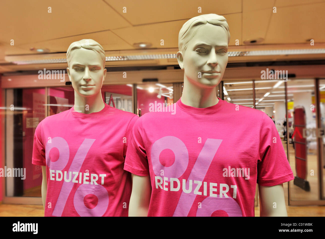 Male mannequins wearing T-shirts labelled reduziert, German for reduced, Munich, Bavaria, Germany, Europe Stock Photo