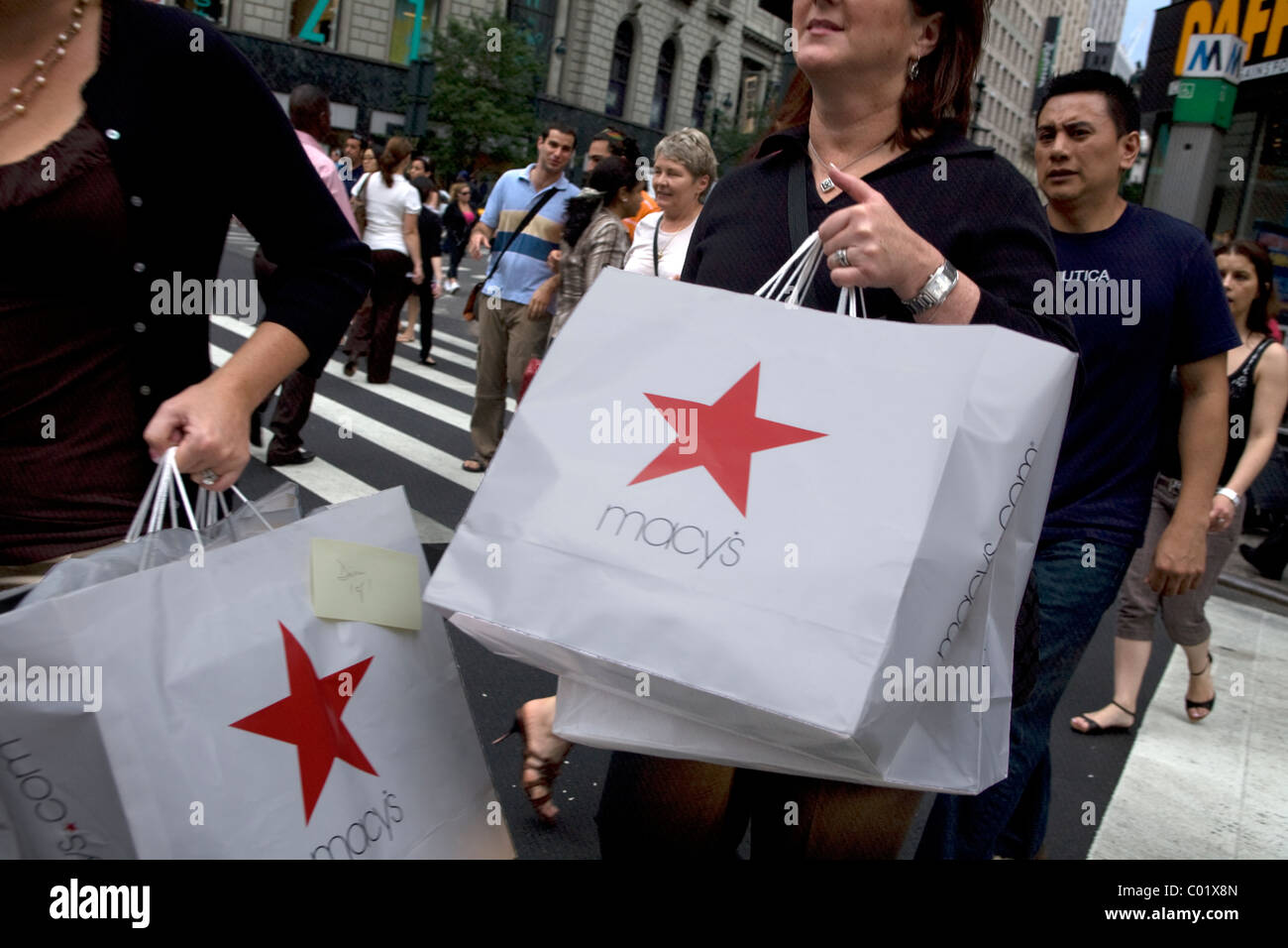 Two serious shoppers with the recognizable Macy's shopping bags on 34th