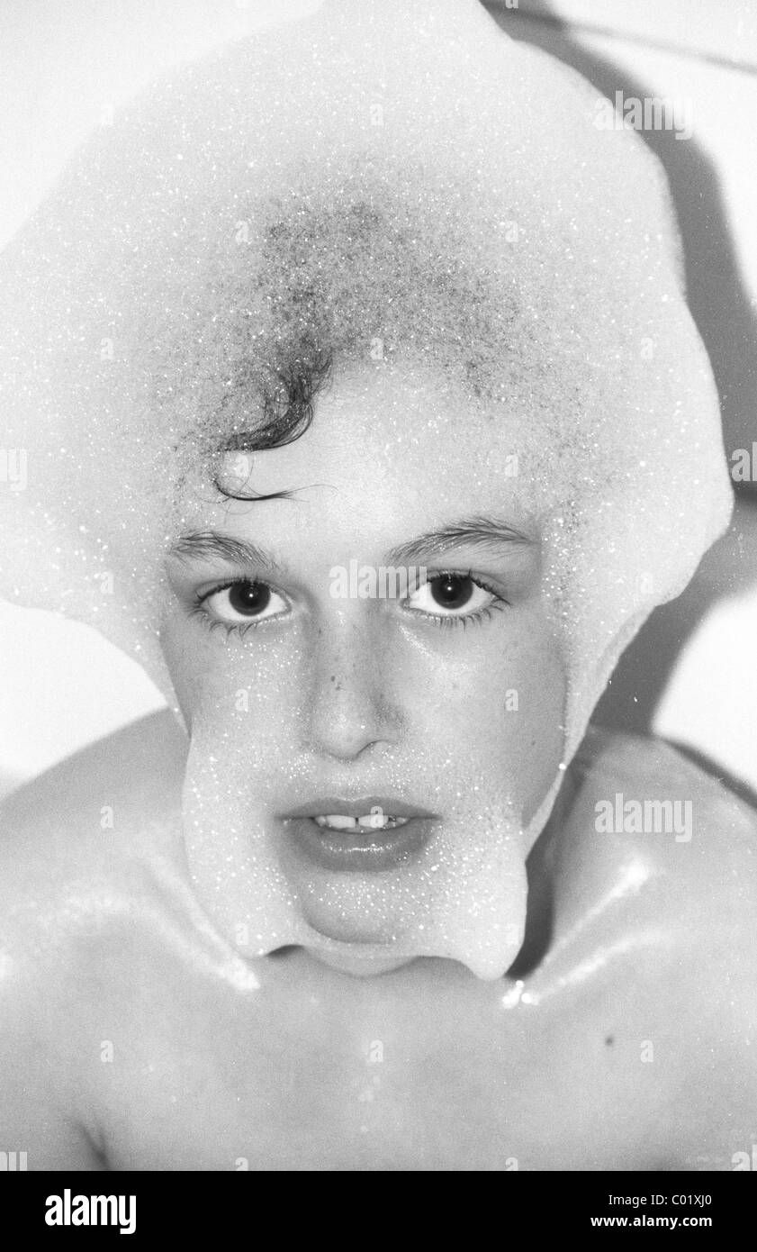 Boy in the bath tub, foam on his head Stock Photo