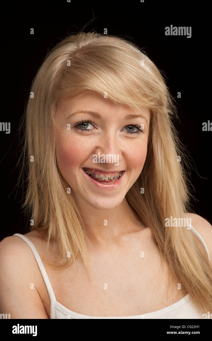 A slim blonde 14 year old teenage girl with dental braces on her teeth, UK Stock Photo