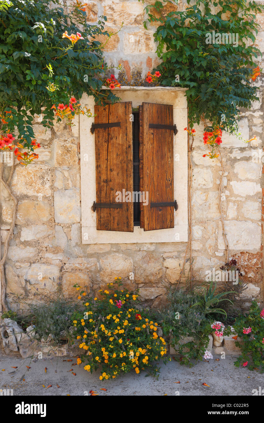 Old traditional stone house in Dalmatia with wooden window and flowers ...
