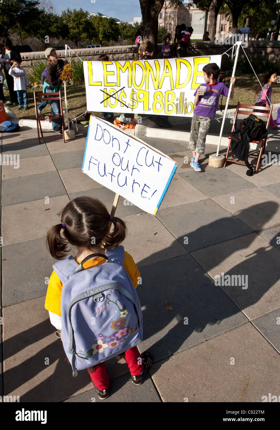 Elementary school aged girl holds sign during protest against education