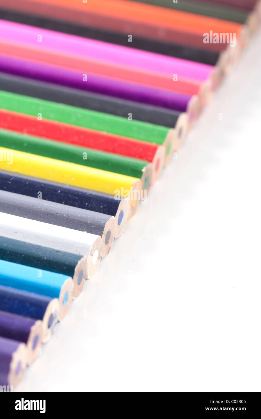 a standard diagonal row of color full colored pencils on white with a small depth of field Stock Photo