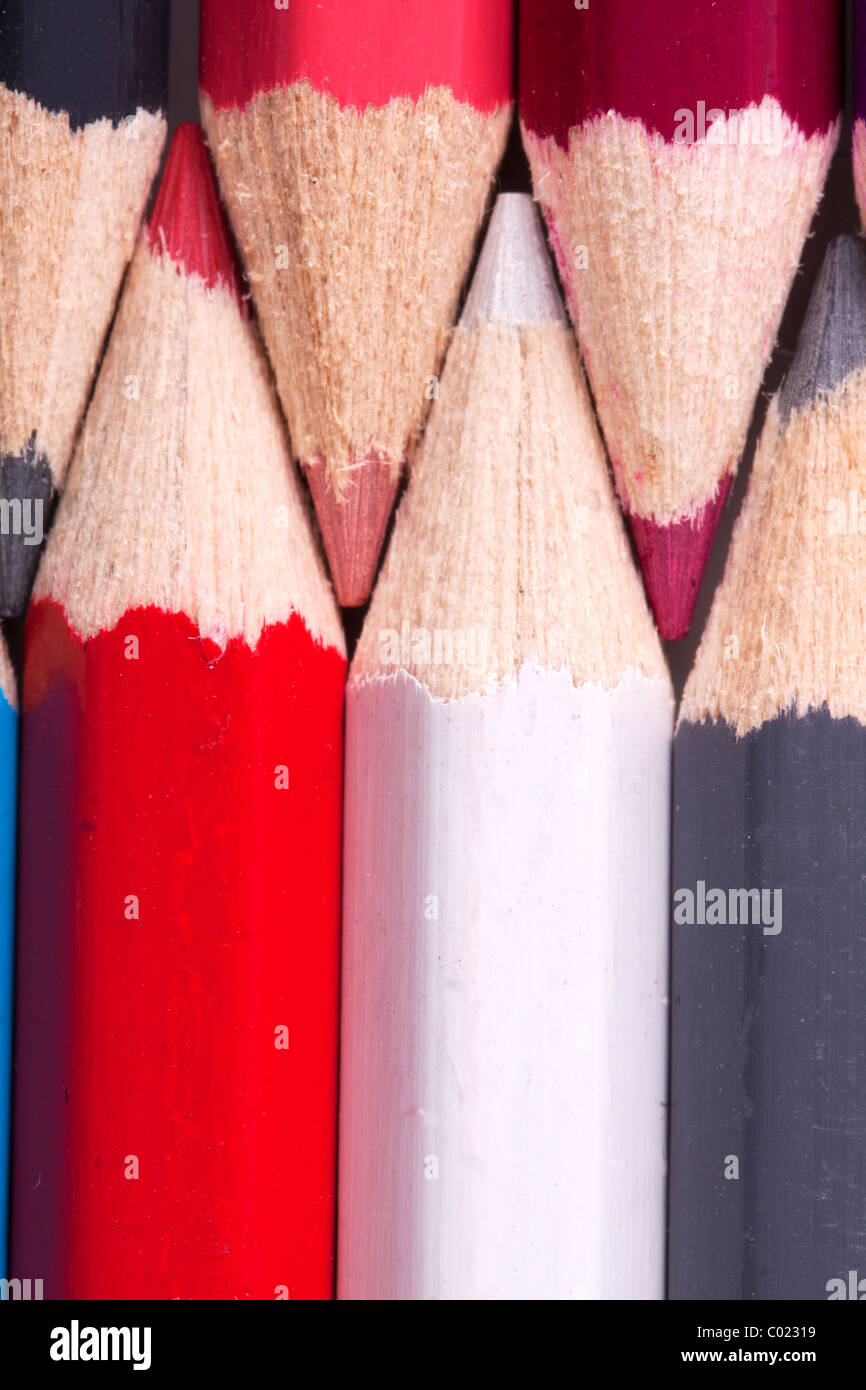 background of a close up of colorfull colored pencils in red, white, grey and purple. Stock Photo