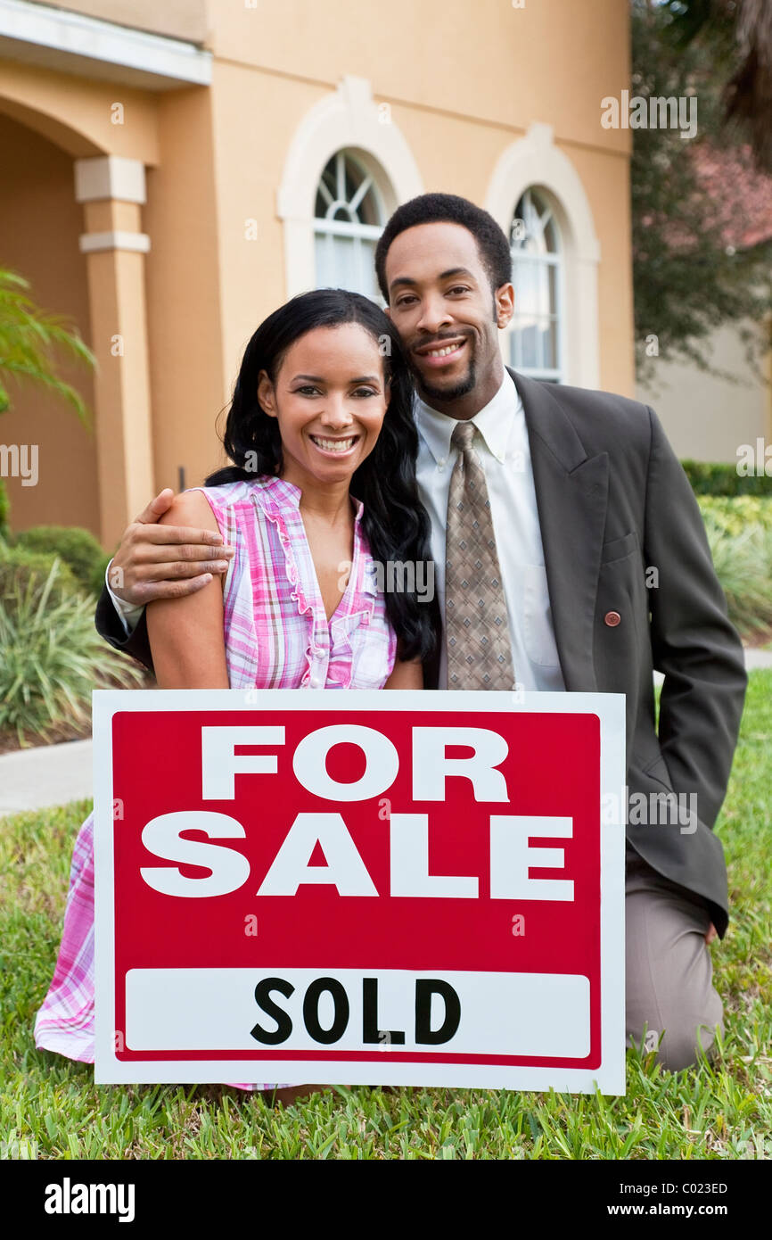 A happy African American man & woman couple outside a house with a For ...