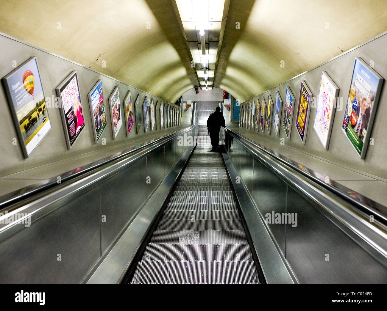 A commuter on a London Underground escalator. Stock Photo