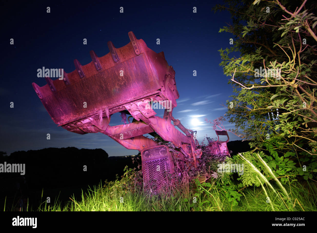 Abandoned farm vehicle in a moon-lit field in North Warwickshire. Stock Photo