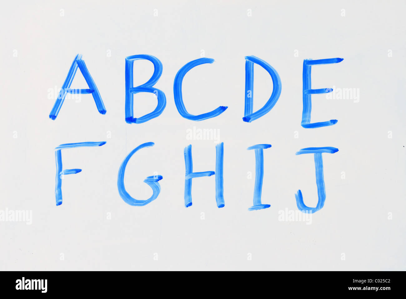the letters A B C D E F G H I J in blue marker on a dry erase white board Stock Photo
