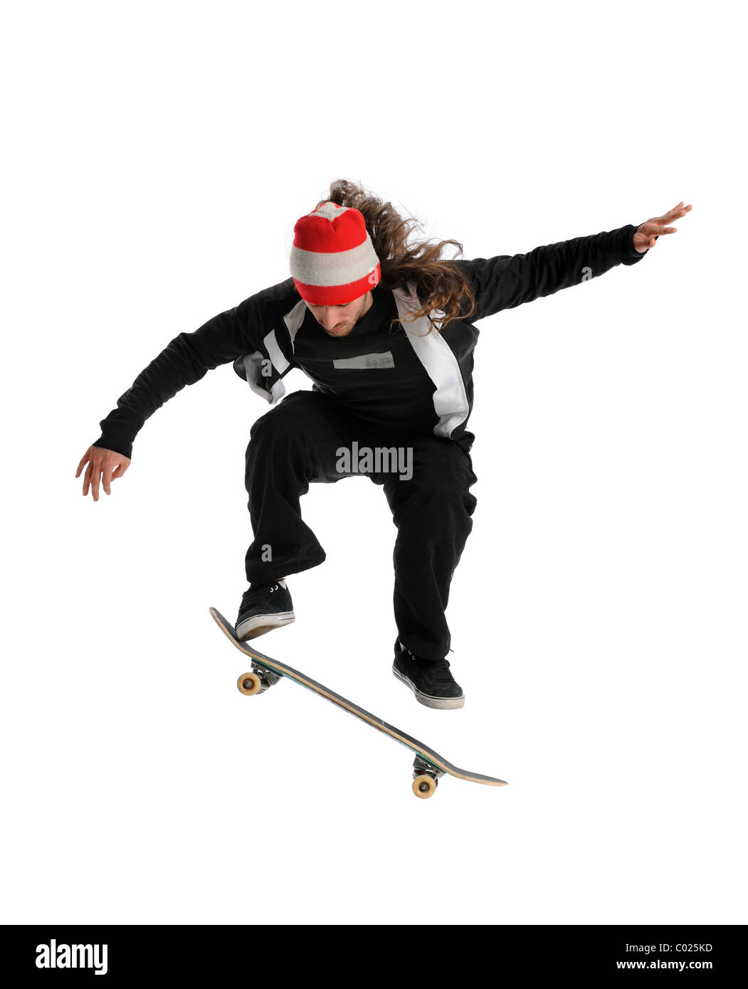 Young skateboarder jumping performing a trick isolated over white background Stock Photo