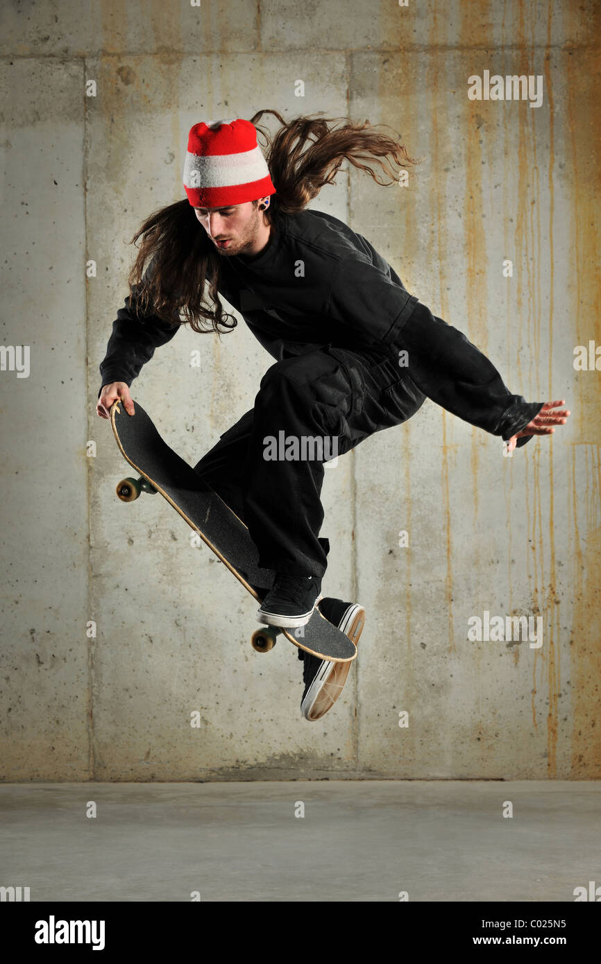 Skateboarder performing jump over grunge building Stock Photo