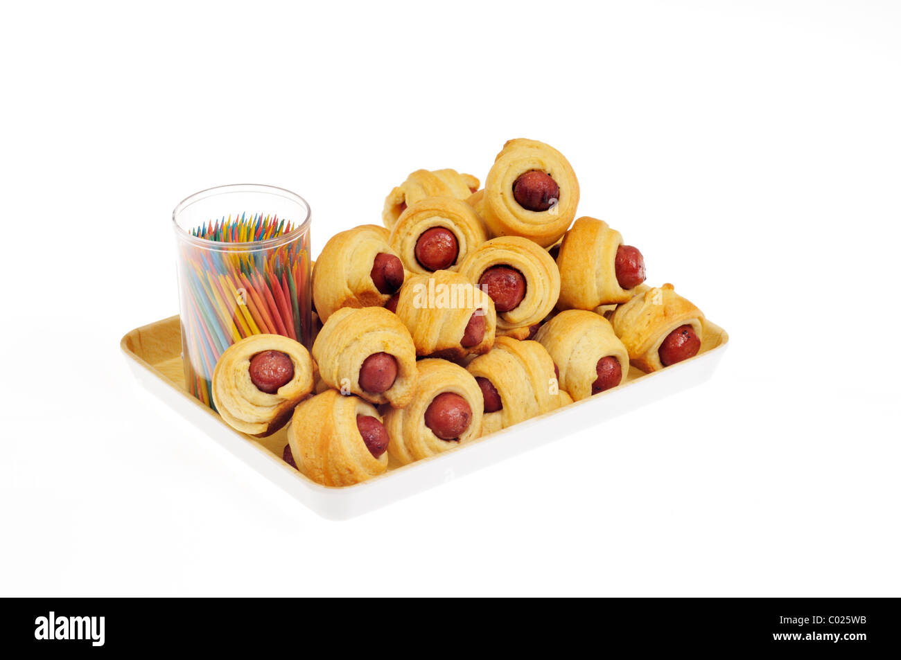 Pigs in a Blanket with toothpicks on serving tray on white background cutout Stock Photo