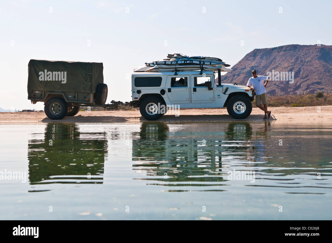 Man standing near his H1 Hummer stacked with surfboards, Requeson, Baja California, Mexico Stock Photo