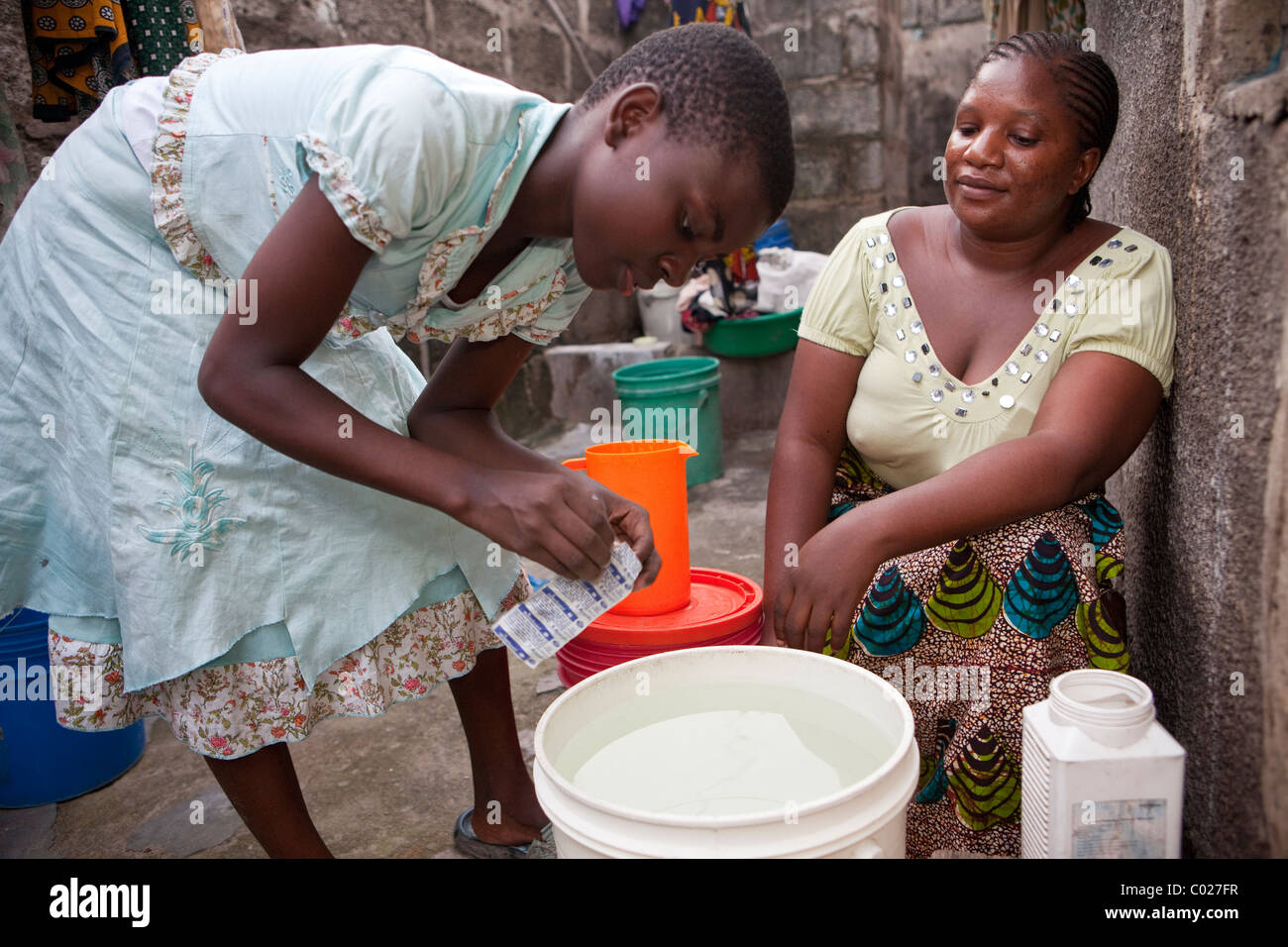 A family uses water purification tablets at home to purify their drinking water. Dar es Salaam, Tanzania, East Africa. Stock Photo