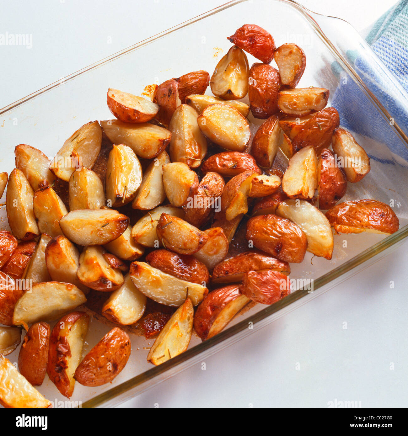 roasted potatoes in glass baking dish with potholder Stock Photo Alamy