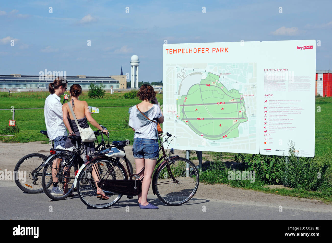 Cyclists in front of a map on the grounds of the former Tempelhof Airport, park opened in 2010 on Tempelhof Feld, Kreuzberg Stock Photo