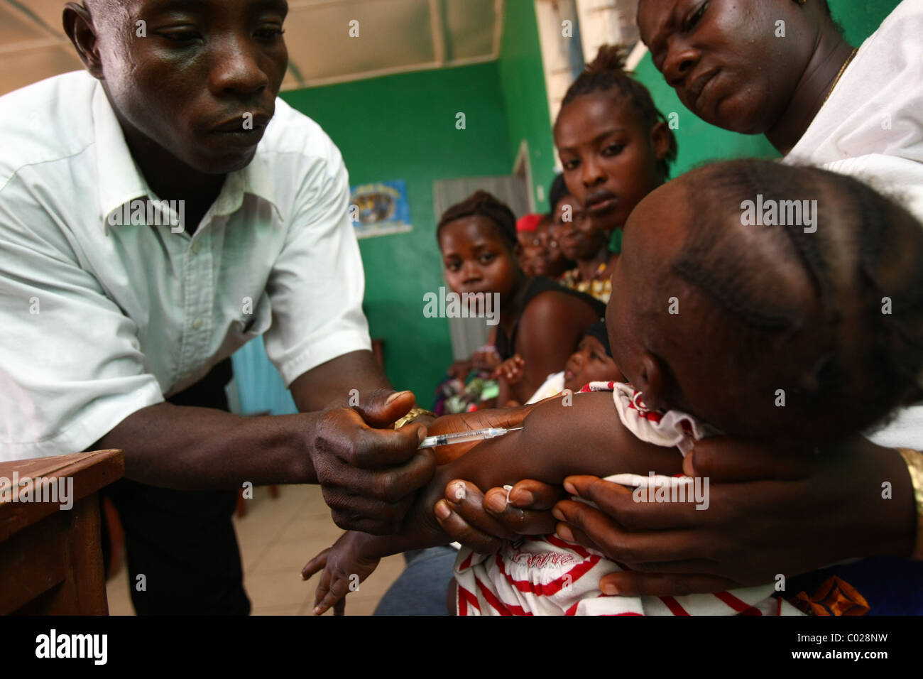 A health worker vaccinates a child against measles at the Masuba health center in the town of Makeni, Sierra Leone Stock Photo