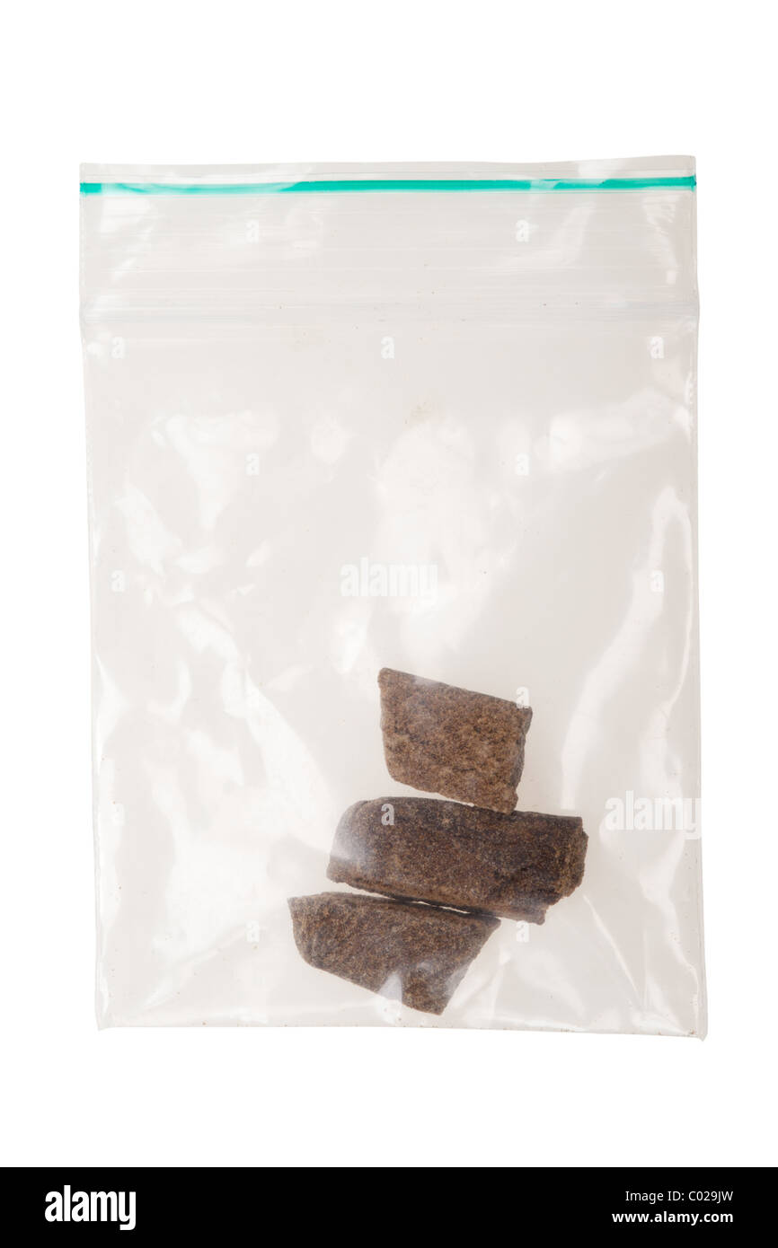 pieces of hashish in a plastic bag , photo taken with a macro lens, isolated on a white background Stock Photo