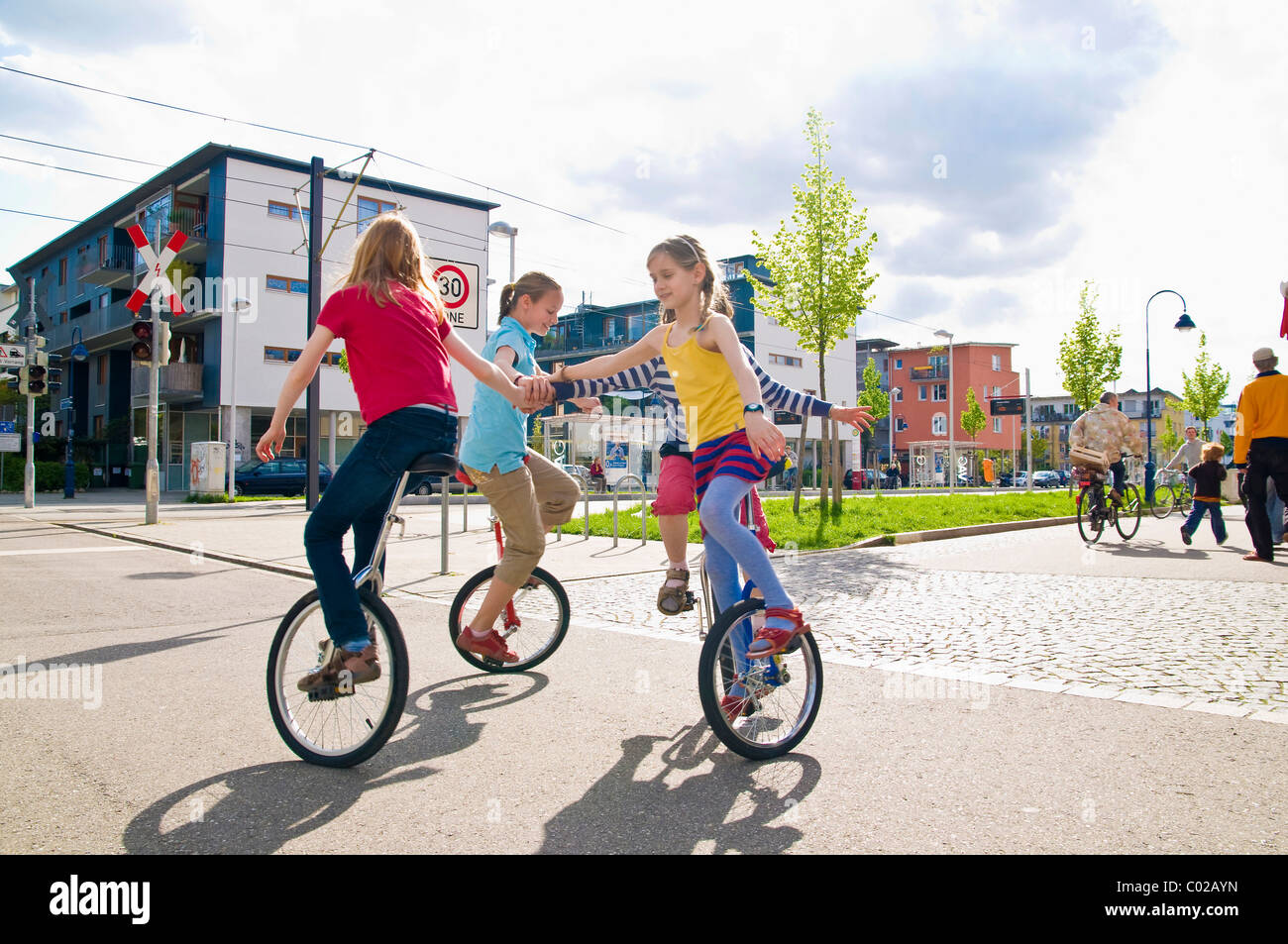 Children on unicycles in a play street, Vauban district in Freiburg im