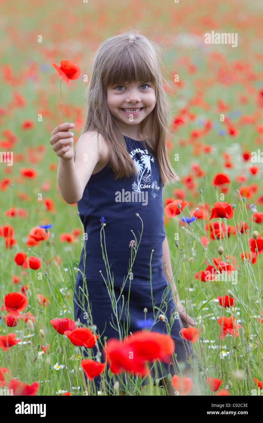 Little girl standing in a poppy field Stock Photo - Alamy