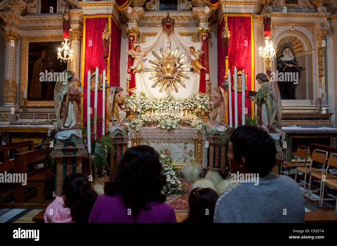 A family admire the splendour of the sepulchre exhibition that is set up in churches in Malta on eve of Good Friday. Stock Photo