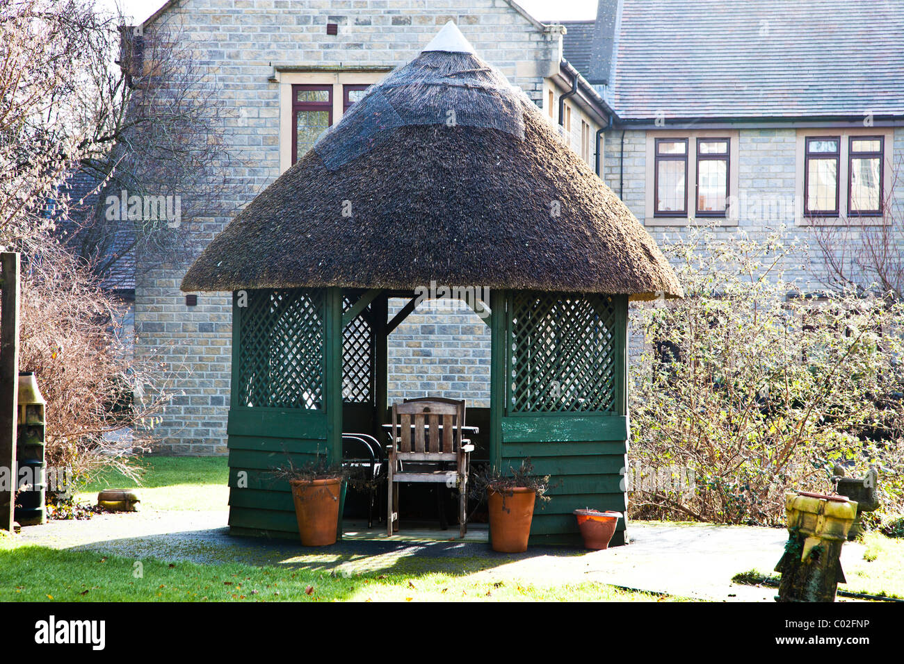 Thatched summerhouse in an English town garden Stock Photo