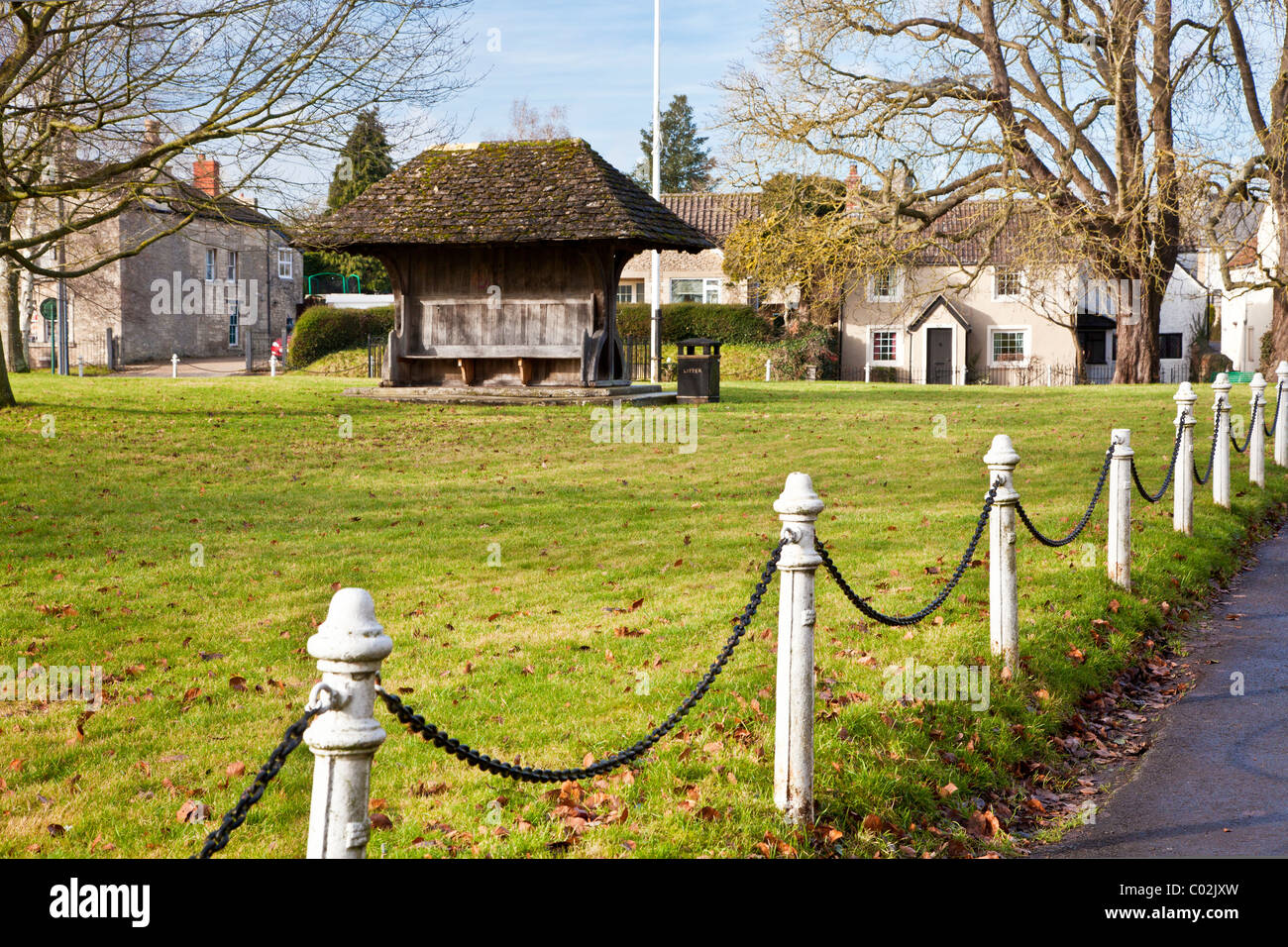 The village green, known as Ham Green, with flagpole and bench, in the village of Holt, Wiltshire, England, UK Stock Photo