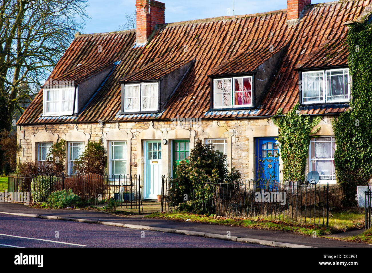 A row of terraced stone cottages with dormer windows and pantile rooves in the village of Holt, Wiltshire, England, UK Stock Photo