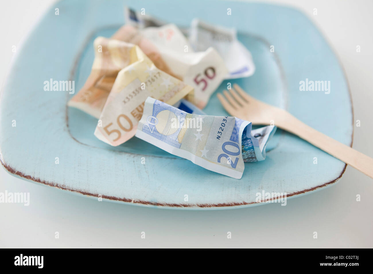 Banknotes on a plate, food costs Stock Photo