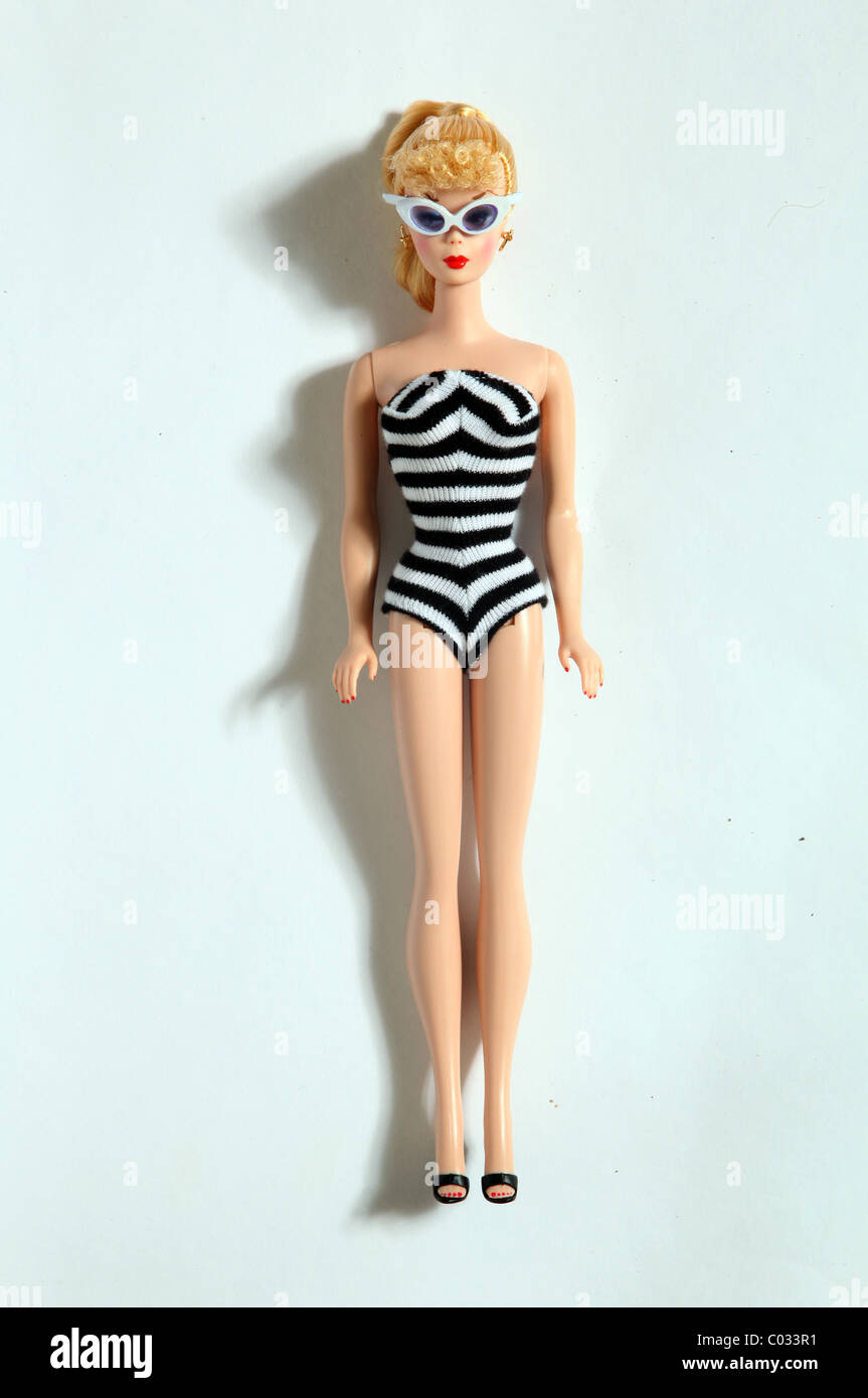 A retro Barbie doll wearing a black and white swimming costume and  sunglasses relaxing Stock Photo - Alamy