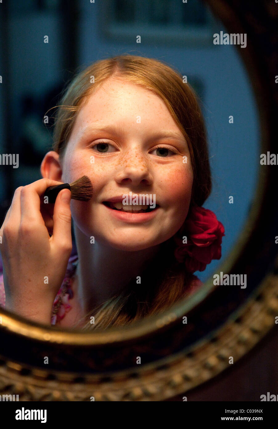 11 year old girl putting on make-up Stock Photo
