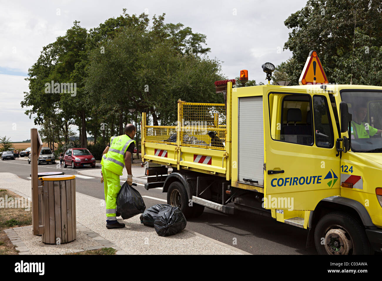 Maintenance cleaning crew removing black bag waste from rest area on A10 (E5) autoroute Eure-et-Loir department France Stock Photo