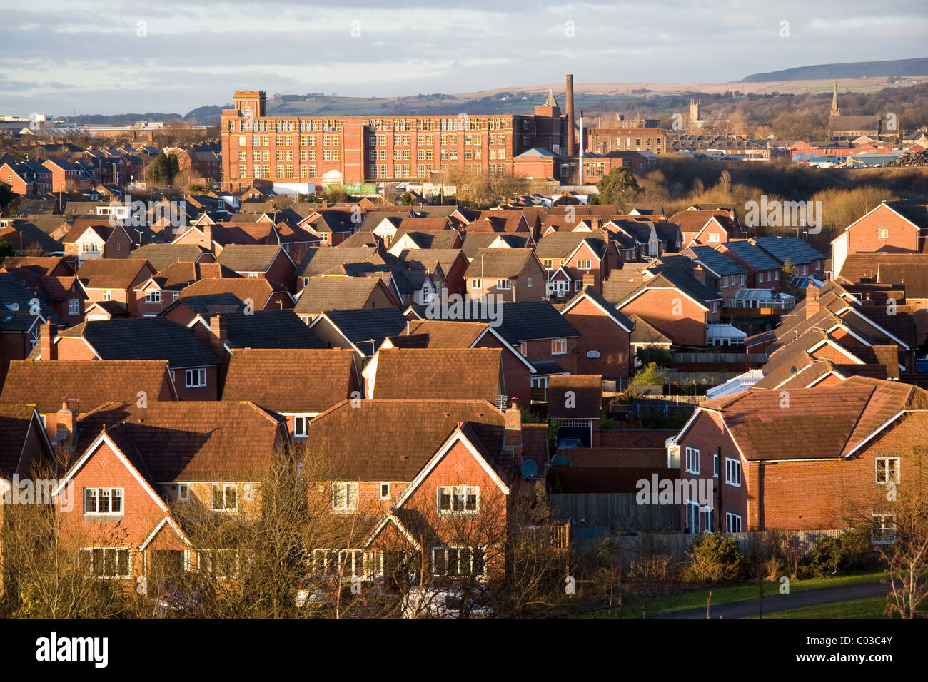 Modern housing estate and old cotton mill (Pilot Mill) with moors beyond, Bury, Greater Manchester, UK Stock Photo