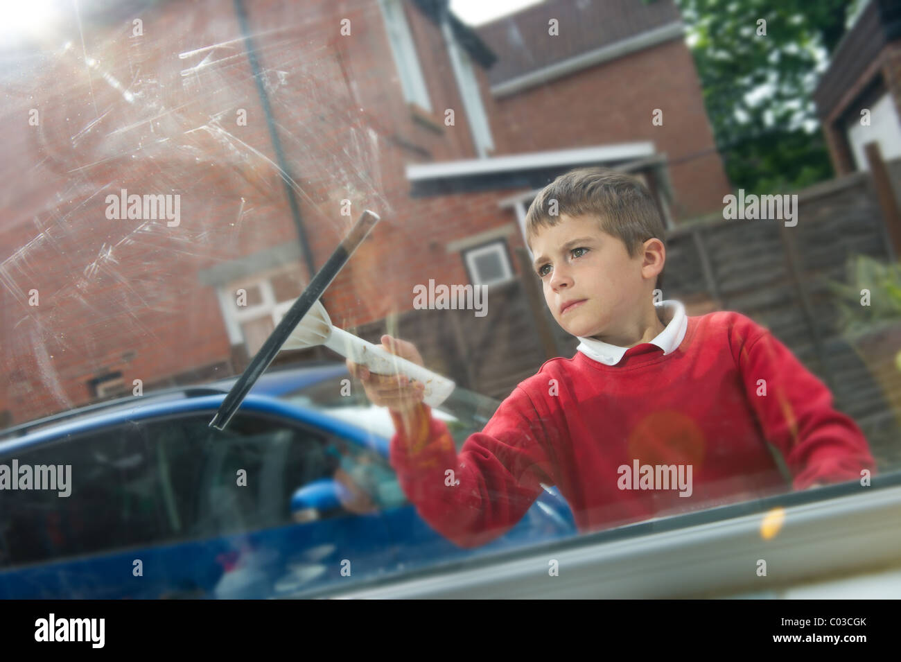 young boy cleaning window for pocket money Stock Photo
