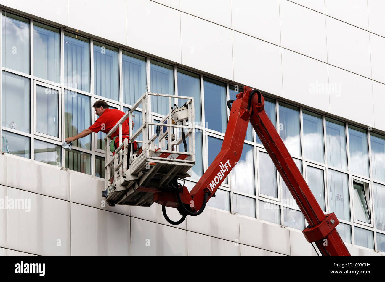 Building cleaner on a boom lift cleaning the windows of Neuss Courthouse, Lower Rhine, North Rhine-Westphalia, Germany, Europe Stock Photo