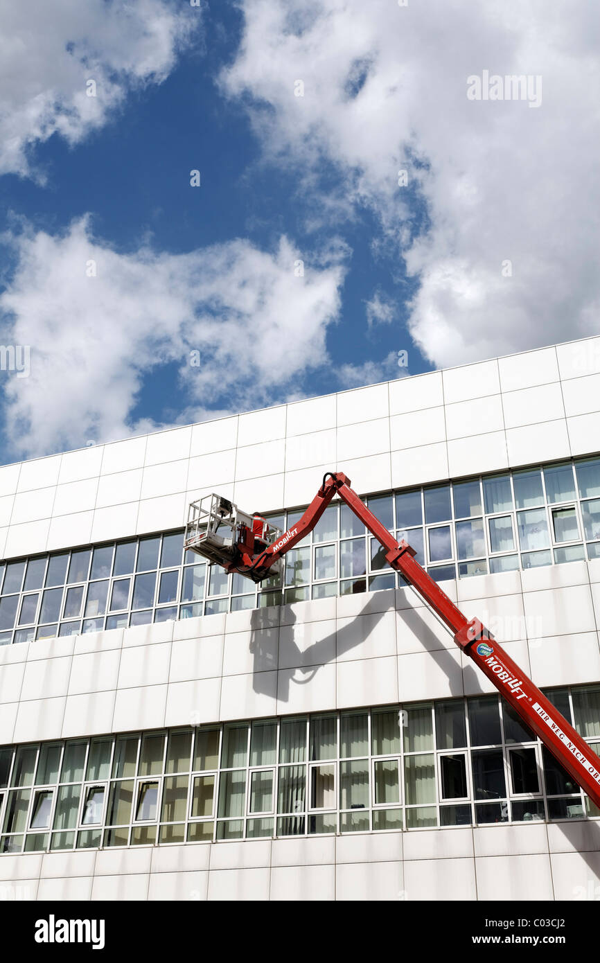 Building cleaner on a boom lift cleaning the windows of Neuss