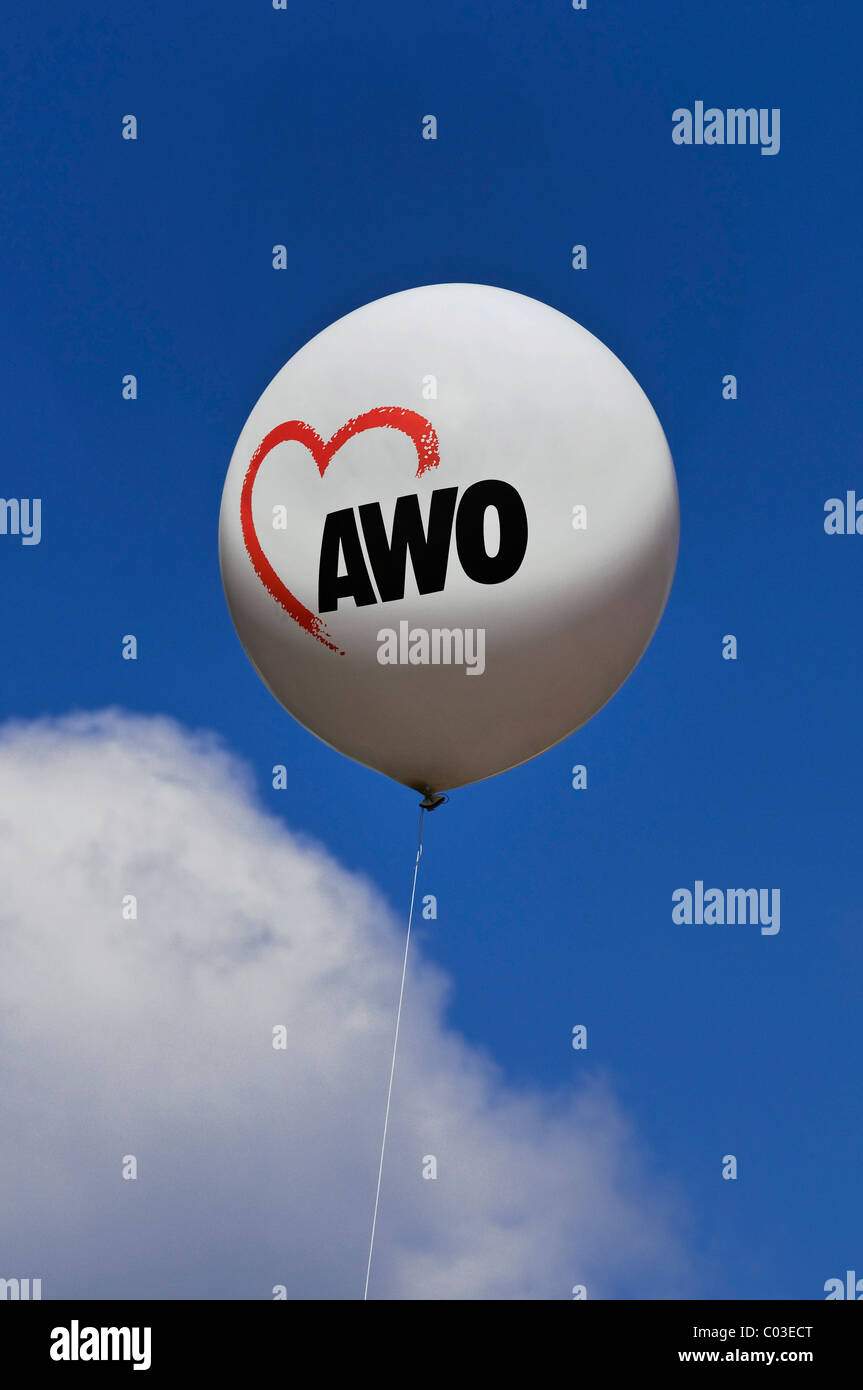 Balloon with an AWO logo against a blue sky with a cloud, AWO, worker's welfare organisation Stock Photo