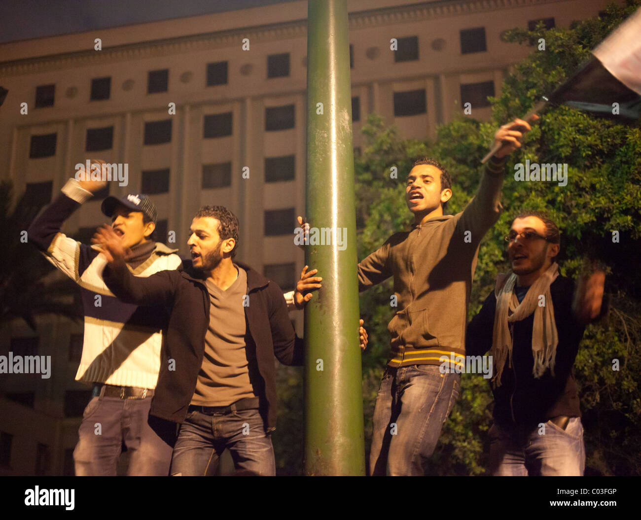 Egyptian demonstrators celebrating victory in the revolution at Tahrir on top of fence Stock Photo
