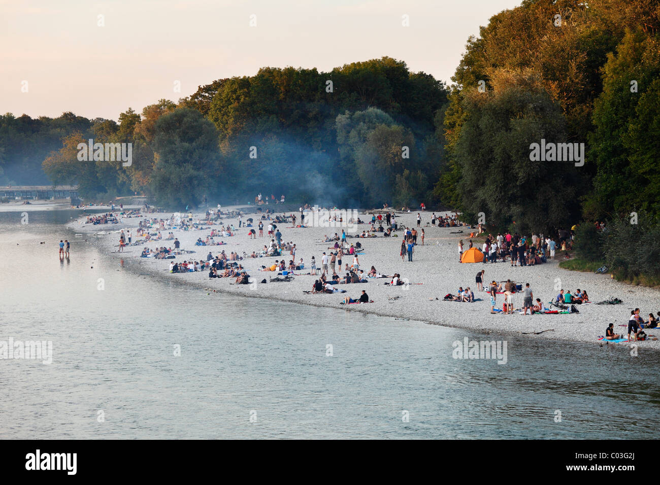 View from Thalkirchener Bridge to the banks of the Isar River, evening with  smoke from barbecue fires, Isar on Flaucher Stock Photo - Alamy