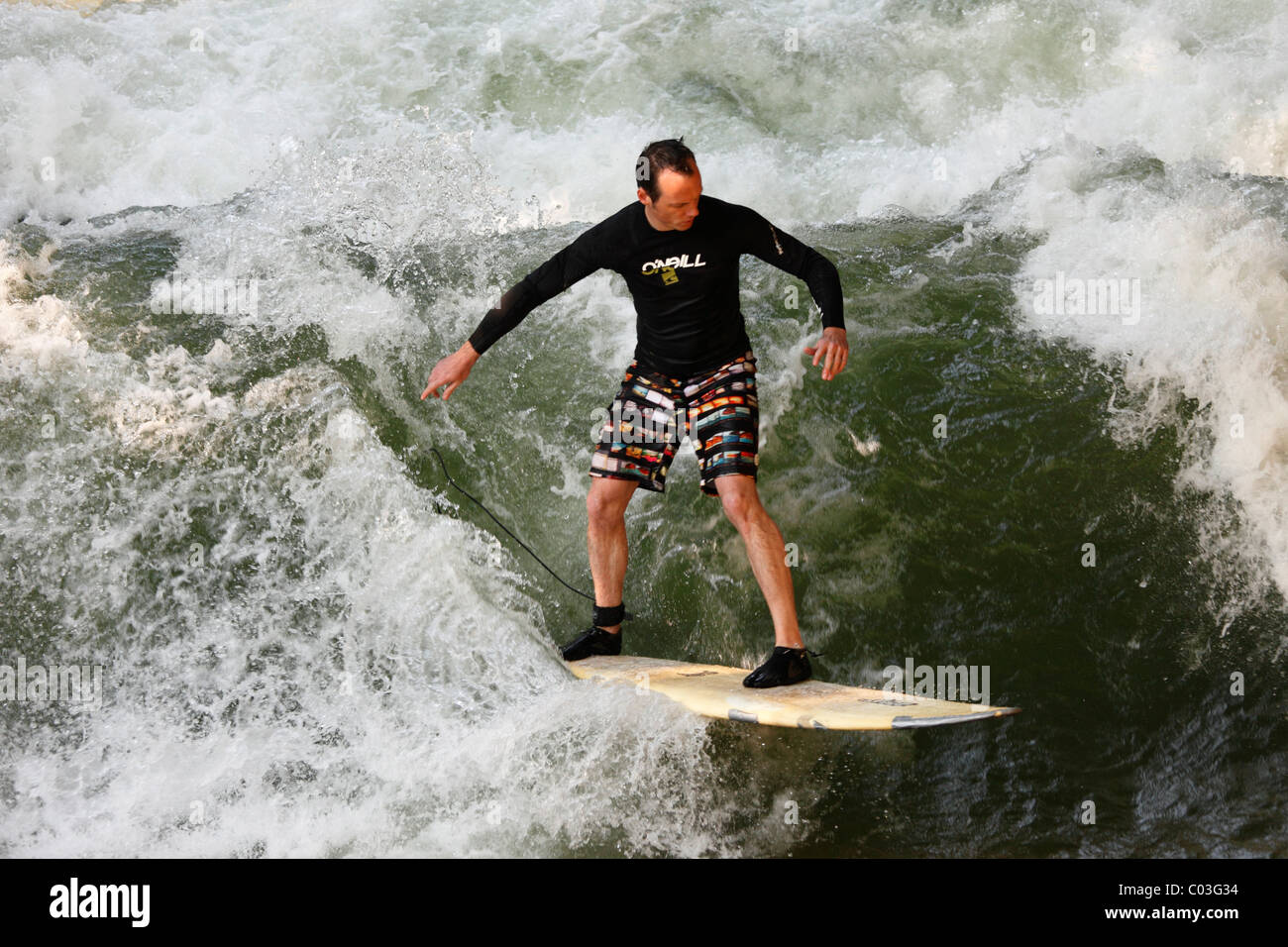 Surfer on a wave in the Eisbach stream, English Garden, Munich, Upper Bavaria, Bavaria, Germany, Europe Stock Photo