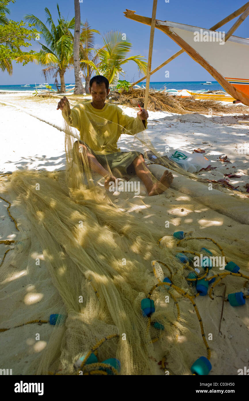 Fischer repair a fishing net, Malapasqua, Philippines, Asia Stock Photo