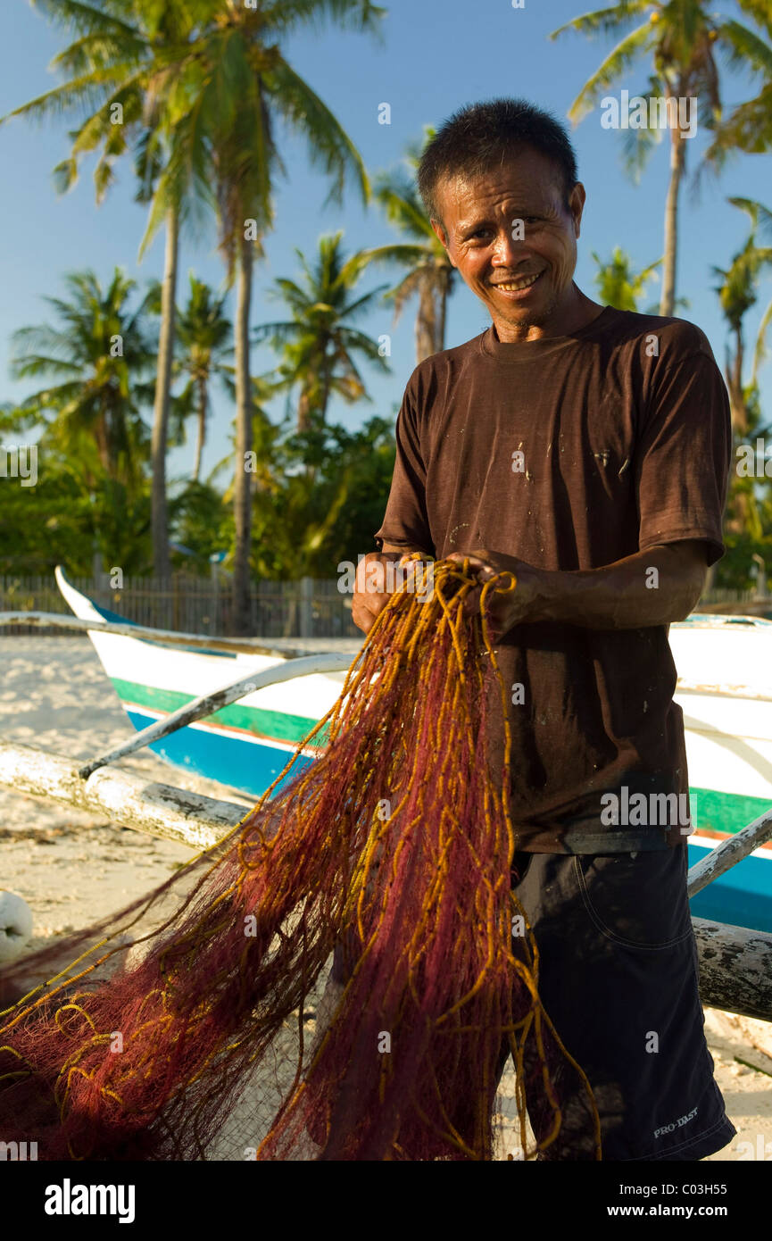 Fisherman repairing a fishing net, Malapasqua, Philippines, Asia Stock Photo