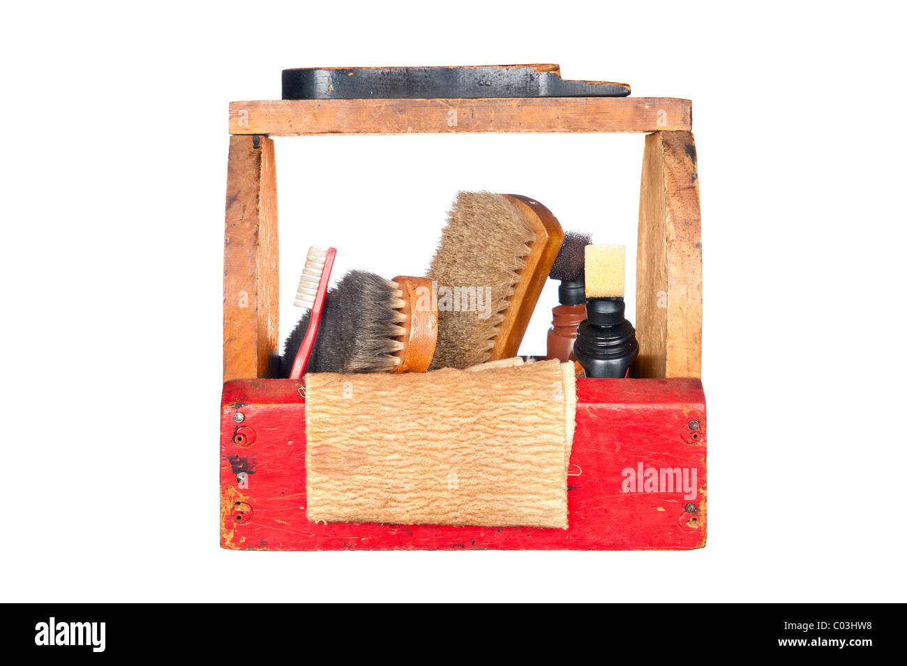 A complete wooden vintage shoe shine box with a shoe platform, camel hair brushes, polishing rag and polish isolated on white. Stock Photo